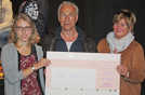 Schauspieler Klaus J. Behrendt und Jutta Thönniges (Tatortverein/rechts) nehmen den Spendenscheck von MPG-Schülerin Mia Seher für ein Projekt in Swasiland in Empfang. 