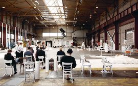 Ensemble und Regieteam von „Der Zauberberg“ proben in einer Halle des ehemaligen Walzwerks.