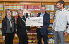 Elke Hermsdorf-Hubertz und Claudia Kuhnen vom Gästeführerverein übergeben einen Spendenscheck an Bibliotheksdirektor Professor Michael Embach und seinen Mitarbeiter Ted Schirmer.