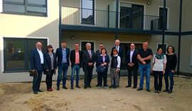 Der Trierer Stadtvorstand mit verschiedenen Projektbeteiligten im Innenhof des neuen Wohngebäudes in Mariahof.