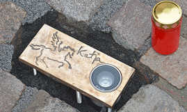 Bronzeplatte im Straßenpflaster mit Lampe, der Aufschrift "Katja" und einem stilisierten Pferd.