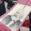 Der Leiter des Amts für Kompilation und Übersetzung Cui überreicht OB Leibe eine Marx-Zeichnung.