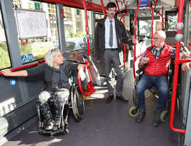 Heike Unterrainer, Mitarbeiterin in der Geschäftsstelle des Behindertenbeirats, Knut Hofmeister vom Verkehrsbetrieb und Behindertenbeauftragter Gerd Dahm diskutieren in einem Bus über die Platzkapazitäten für Rollstuhlfahrer. 