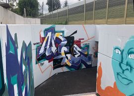 Großflächige, bunte Graffiti in einer Unterführung