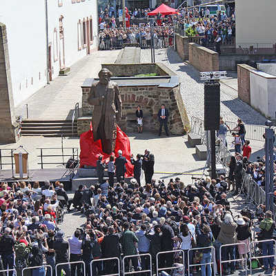 Zahlreiche „Ohs“ und „Ahs“ der Festgäste begleiten die Enthüllung der mit Sockel 5,50 Meter hohen Statue. Auf dem Simeonstiftplatz und rund um die Kutzbachstraße herrscht großer Besucherandrang.