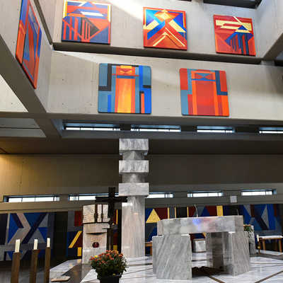 Der Altarraum ist von dem Künstler Otto Herbert Hajek gestaltet worden. Die farbenfrohen Tafelbilder heben sich deutlich vom Grau des Betons und des Marmors in dem Gebäude aus den 60er Jahren ab. Foto: TTM
