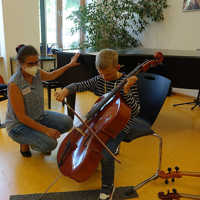 Lehrerin Barbara Konder leitet die ersten Streichbewegungen auf dem Violoncello an.