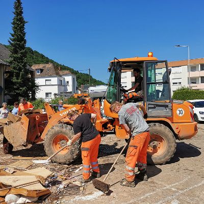 Mitarbeiterinnen und Mitarbeiter des Amtes StadtRaum räumen große Mengen an Dreck und Sperrmüll aus dem überschwemmten Stadtteil Trier-Ehrang weg. Foto: Jürgen Feltes