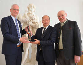OB Wolfram Leibe, der chinesische Weinunternehmer JinBo Xu und Adolf Schmitt (Saar-Mosel-Winzersekt GmbH. v. l.) präsentieren den Eiswein, der 2015 eine Auszeichnung erhielt.