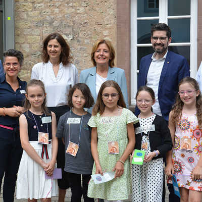 Junge Bücherfreundinnen freuen sich auf den Lesesommer und durften zum Auftakt Ministerpräsidentin Malu Dreyer (hinten, 3. v. r.) mit ihren Begleiterinnen und Begleitern durch die Stadtbücherei führen. 