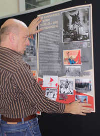 VHS-Leiter Rudolf Fries testet im Foyer die Positionierung eines Plakats für die neue Ausstellung.