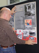 VHS-Leiter Rudolf Fries testet im Foyer die Positionierung eines Plakats für die neue Ausstellung. QR-Codes ermöglichen es den Besuchern, sich vertiefend über einzelne Schwerpunkte zu informieren. 