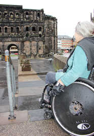 Rollstuhlfahrerin an der Rampe zum Porta-Nigra-Vorplatz