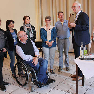 Projektkoordinatorin Uta Hemmerich-Bukowski und Oberbürgermeister Wolfram Leibe (v. r.) überreichen den Sprechern von sechs der acht Arbeitsgruppen ein Weinpräsent als Zeichen der Anerkennung für ihr großes Engagement.