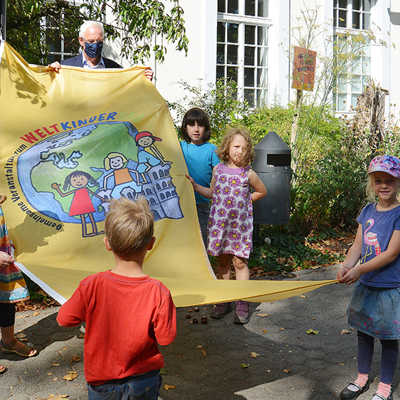 Mehrere Mitglieder des Netzwerks brachten ihre Kinder mit, die zusammen mit  OB Wolfram Leibe die Fahne präsentieren.