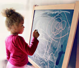 Ein Kind malt an einer Zeichentafel