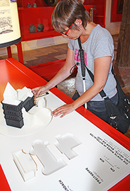 Museumsbesucherin Sabrina Knopp vergegenwärtigt sich anhand des 3D-Modells mit Baukastenelementen die Architektur der Porta Nigra im Mittelalter.