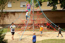 Kinder entdecken die Kletterspinne des neuen Spielplatzes