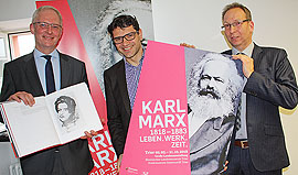 Wolfram Leibe, Salvatore Barbaro und Rainer Auts präsentieren das Corporate Design der Marx-Ausstellung.