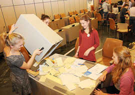 Wahlhelferinnen kippen eine Urne mit Stimmzetteln aus.