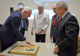 OB Wolfram Leibe (l.) schneidet den Kuchen an, der den neuen Namen der Berufsbildenden Schule trägt.
