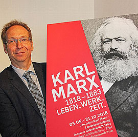 Geschäftsführer Dr. Rainer Auts präsentiert das Plakat für die Trierer Ausstellung zum 200. Geburtstag von Karl Marx.