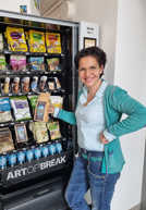 Andrea May, Leiterin der Stadtbücherei, präsentiert im Lesecafé den neuen Automaten mit fairen Produkten.