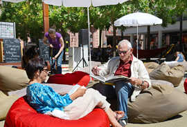 Ulla Grass und Horst Heimbach lesen bei strahlendem Sonnenschein auf dem Kornmarkt.