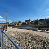 Baustelle an einer Eisenbahnstrecke mit Betonelementen und einer planierten Schotterfläche