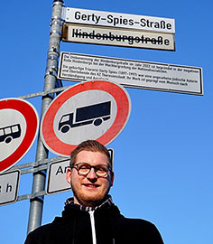 Matthias Koster (Die Linke) vor dem neuen Straßenschild in der Gerty-Spies-Straße.
