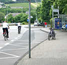 Radfahrer auf dem Weg vom Stadtbad zum Kaiserthermenkreisel – zur Zeit noch ohne eigene Fahrspur. Rechts im Bild die Bushaltestelle am Stadtbad.
