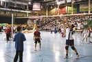 Action, Spaß und Gemeinschaftserlebnis in der Arena: Eine Übungsleiterin des TuS Holzerath bei einer Volleyballübungseinheit mit zwei Schülern.