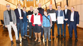 Gruppenbild mit den verabschiedeten Ortsvorstehern und ihren Nachfolgern in einem Saal.