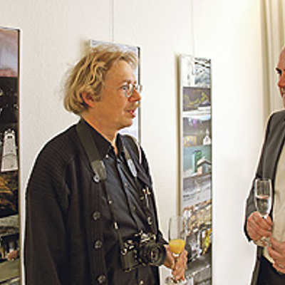 Johannes Oberdorf diskutiert bei der Ausstellungseröffnung mit Hobbyfotograf Thomas Egger über die Vor- und Nachteile digitaler Fotografie. Oberdorf selbst arbeitet häufig noch mit analogen Kameras und sammelt diese mit Leidenschaft.