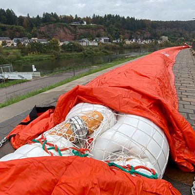 Das Mobildeichsystem liegt auf der Deichkrone auf. Die 40 Meter langen Einzelteile werden miteinander verbunden. Die Plane über den Schläuchen dient dazu, dass kein Wasser unter die Schläuche läuft und das System weggedrückt wird