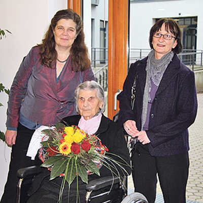 Bürgermeisterin Angelika Birk (l.) und Jutta Föhr, Ortsvorsteherin von Trier-Süd (r.), reihen sich in die Schar der Gratulanten zum 100. Geburtstag von Katharina Werner ein.