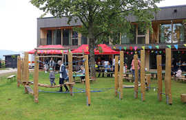 Blick auf den Spielplatz mit dem neue Kitagebäude im Hintergrund und Gästen der Einweihungsfeier