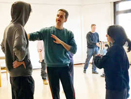 Besprechung zwischen einem Tanzlehrer und seinen Schülern.