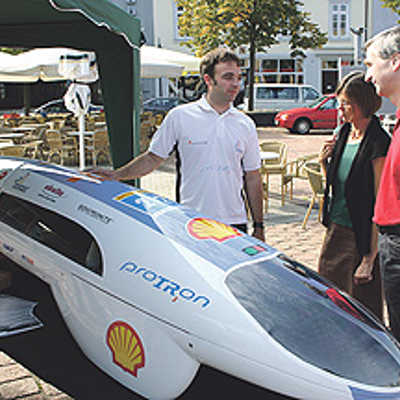 FH-Student Ulrich Wohner (l.) zeigt Besuchern das Mobilitätstages das Energiesparmobil "Protron".