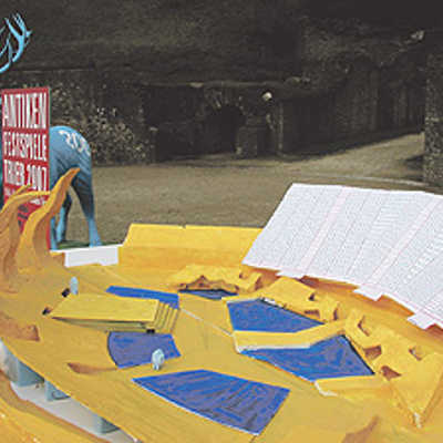 Das Modell zeigt die Bühnenkonstruktion von Francois Valentiny. Die ersten drei Sitzreihen auf der Tribüne (rechts in weiß) sind noch im Rund der Arena in drei Meter Höhe, die restlichen entlang der Hänge. Die blauen Bereiche stehen für Wasserflächen.