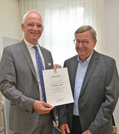 Oberbürgermeister Wolfram Leibe präsentiert die Urkunde für Gerhard Thesen zur Versetzung in den Ruhestand.