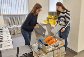 Kristina Reis und Antonia Willger vom Wahlbüro (v. l.) packen zwei Ordner für das Wählerverzeichnis sowie ergänzende Unterlagen in den Koffer für eines der 66 Wahllokale im Stadtgebiet.