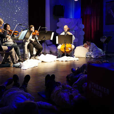 Beim Kinderkonzert „So klingen meine Träume“ gehen die Kinder mit Musikpädagogin Lucia Pedretti (rechts, liegend) auf eine Reise ins Wunderland der Klänge. Foto: Theater Trier