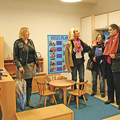 Kindergartenleiterin Karin Scholzen (Mitte) stellt Bürgermeisterin Angelika Birk (r.) und drei Ausschussmitgliedern eine Spielecke vor. Jede Kindergartengruppe ist nach einer Farbe benannt.