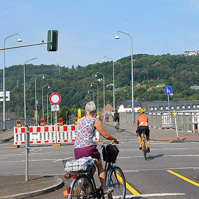 Radfahrerinnen und Radfahrer überqueren die autofreie Römerbrücke zu Beginn der aktuellen Bauarbeiten.
