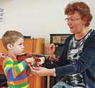 Unter Anleitung von Dozentin Yewgenia Uchlina probiert ein kleiner Besucher eine Suzuki-Violine aus. Sie ist geeignet für Kinder ab vier Jahre. Foto: Musikschule