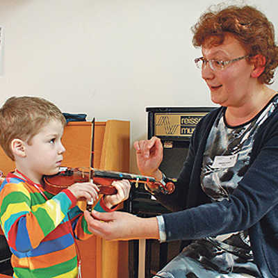Unter Anleitung von Dozentin Yewgenia Uchlina probiert ein kleiner Besucher eine Suzuki-Violine aus. Sie ist geeignet für Kinder ab vier Jahre. Foto: Musikschule