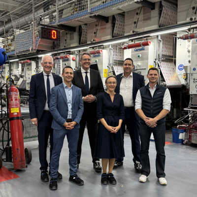 Oberbürgermeister Wolfram Leibe (hinten links) besuchte gemeinsam mit Ministerpräsident Alexander Schweitzer (hinten, 2. v. l.) das Unternehmen MM Gravure in der Diedenhofener Straße. Nico Nesselhauf, Geschäftsführer Jochen Molt und Elke Kranzl (v. r.) von der MM Group erläuterten Details bei einer Werksbesichtigung. Mit dabei war auch Eric Krischel von der städtischen Wirtschaftsförderung (vorne links).