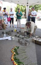 Der Kölner Künstler Gunther Demnig verlegt die Stolpersteine vor dem MPG-Haupteingang. Viele Besucher haben zur Erinnerung an die NS-Opfer Rosen niedergelegt. 
