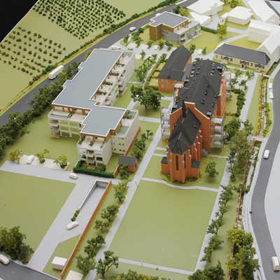 Der Blick auf das Modell des Architekturbüros Beckhäuser zeigt die Anordnung der neuen Wohngebäude (links) auf dem Klostergelände in Olewig. Im Zusammenspiel mit dem Altbau (rechts) entsteht ein quadratischer Innenhof.